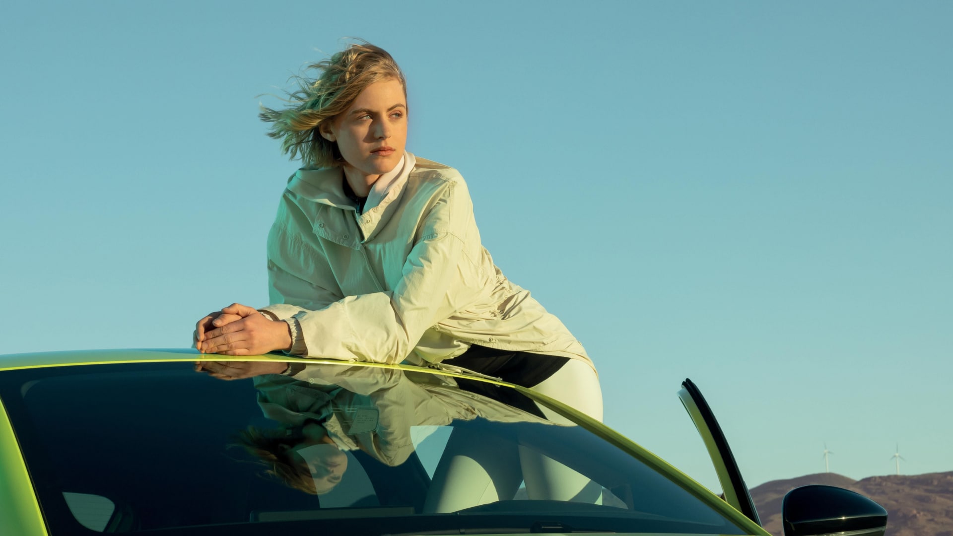 Een vrouw leunt tegen een PEUGEOT 208